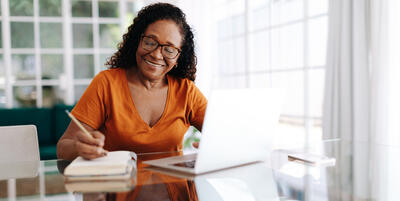 Woman smiling while sitting at a computer. 